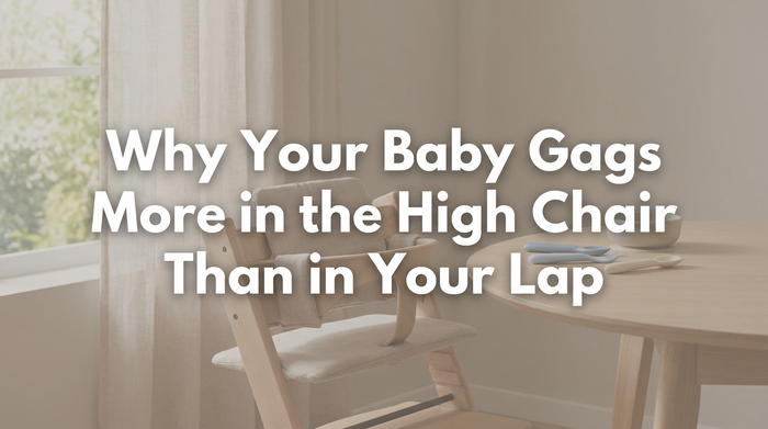 Baby sitting in high chair being fed by parent in bright kitchen