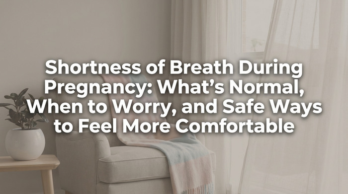 Pregnant woman sitting upright on bed taking a deep breath with hand on chest