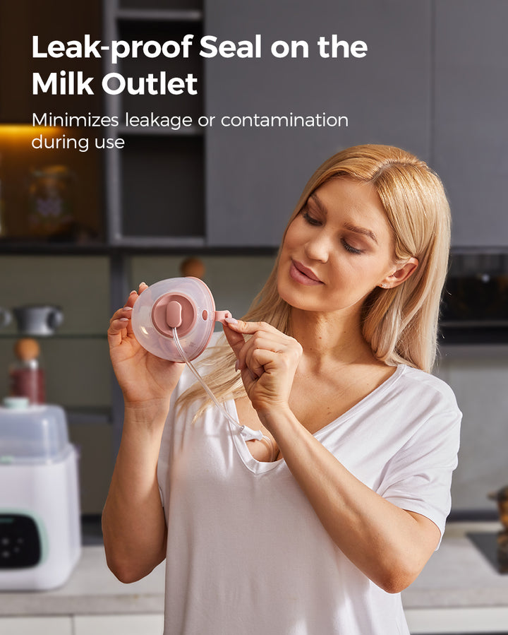 Woman demonstrating leak-proof seal on breast pump's milk outlet in a kitchen.