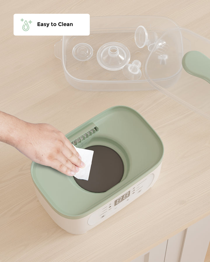 Hand cleaning the 8-in-1 baby bottle steam sterilizer with a cloth, showcasing the easy-to-clean feature. The sterilizer lid with components is placed nearby. Tag reads 'Easy to Clean'.