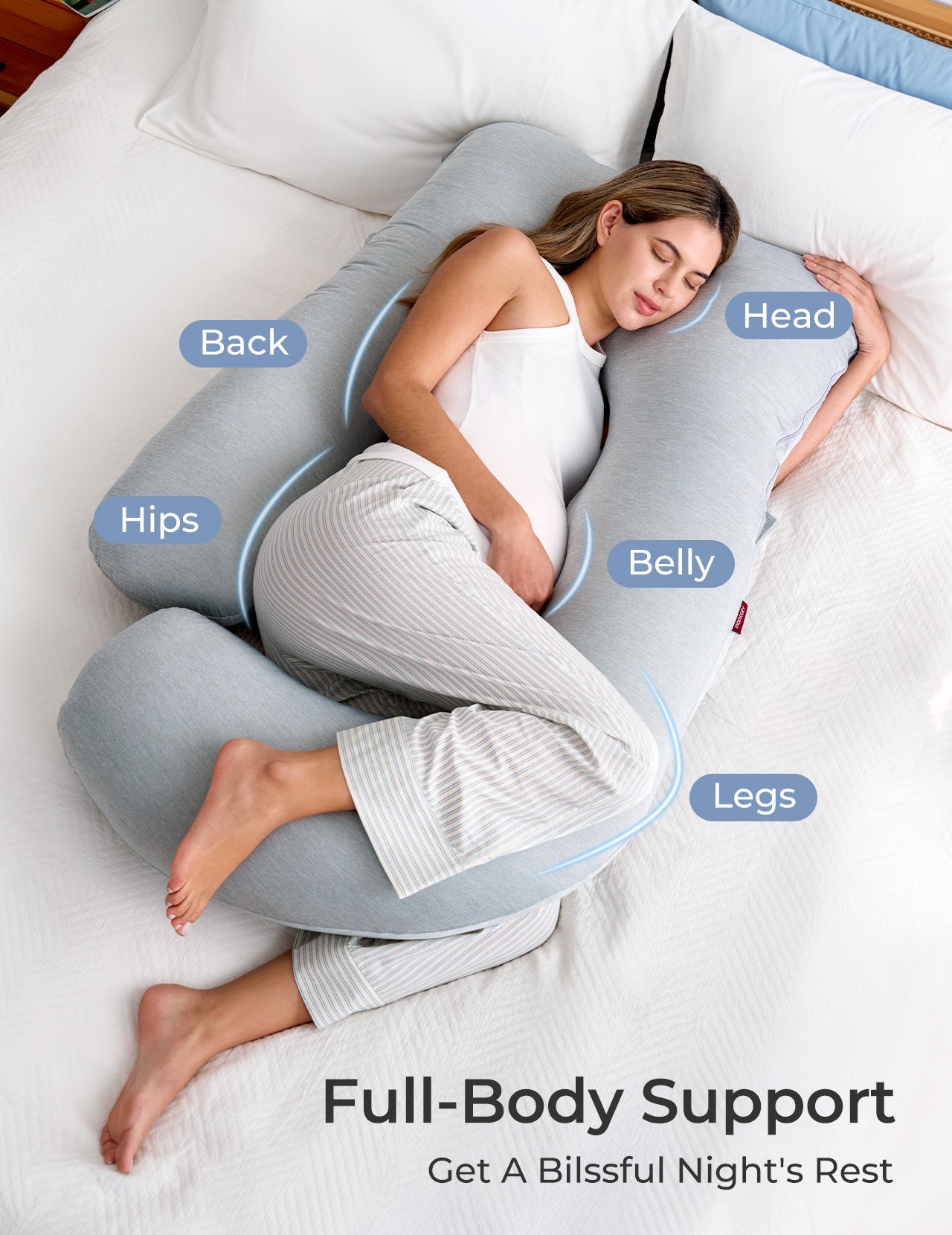 Future maman installée avec un coussin de grossesse Momcozy en forme de U