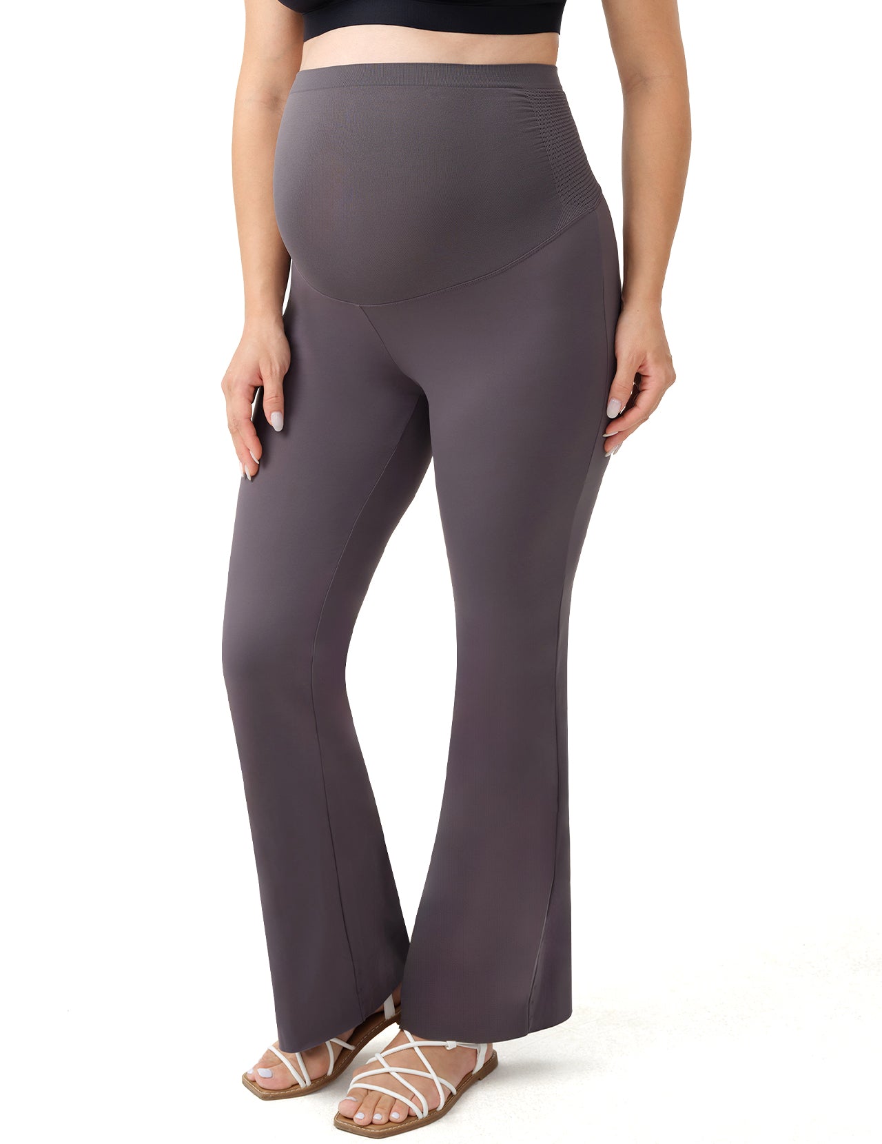 Pregnant woman in grey flared maternity leggings for comfortable workouts.