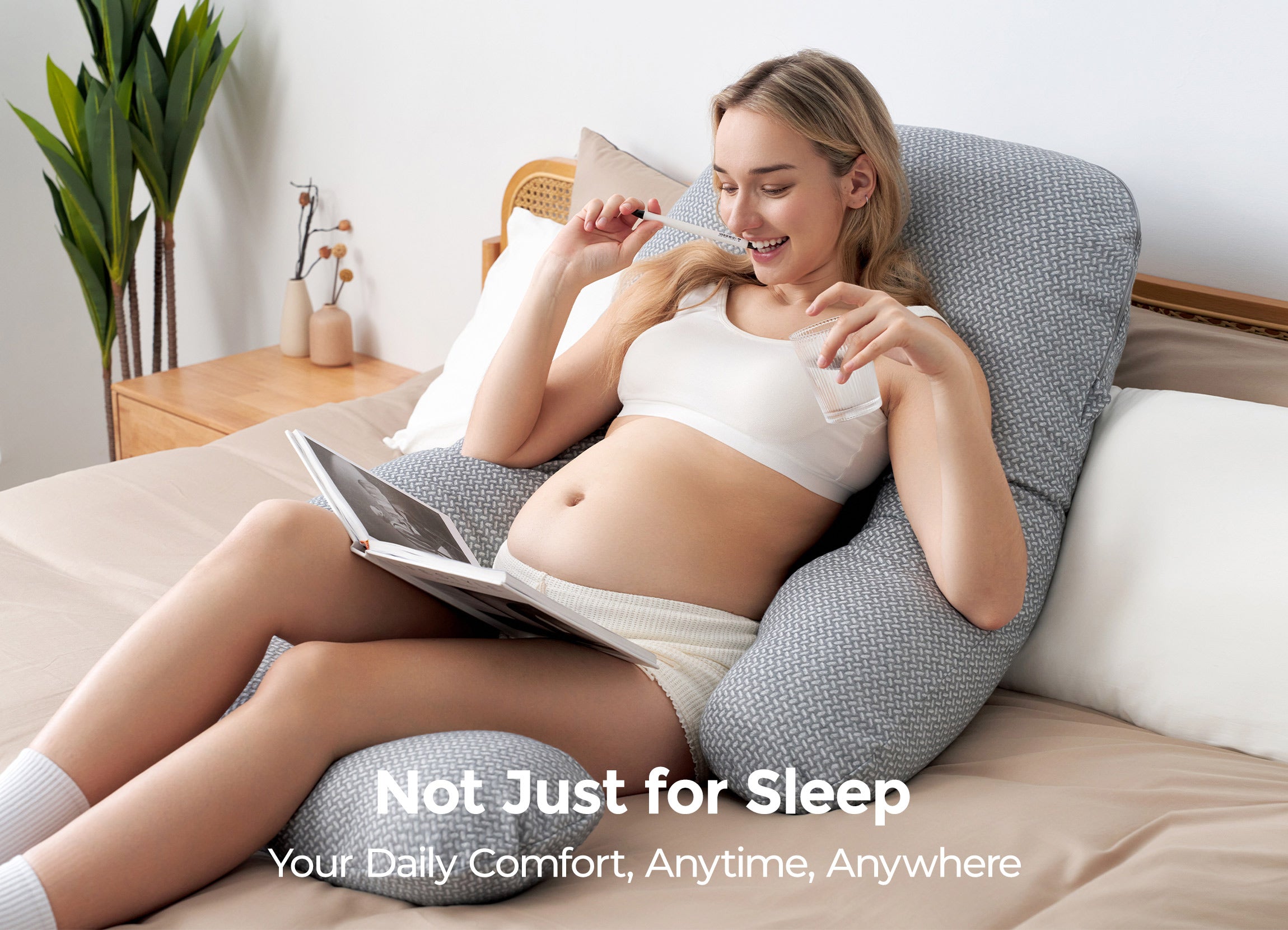 Momcozy Dreamlign pillow: Pregnant woman relaxing on bed, using grey support for comfort and well-being, anytime, anywhere.