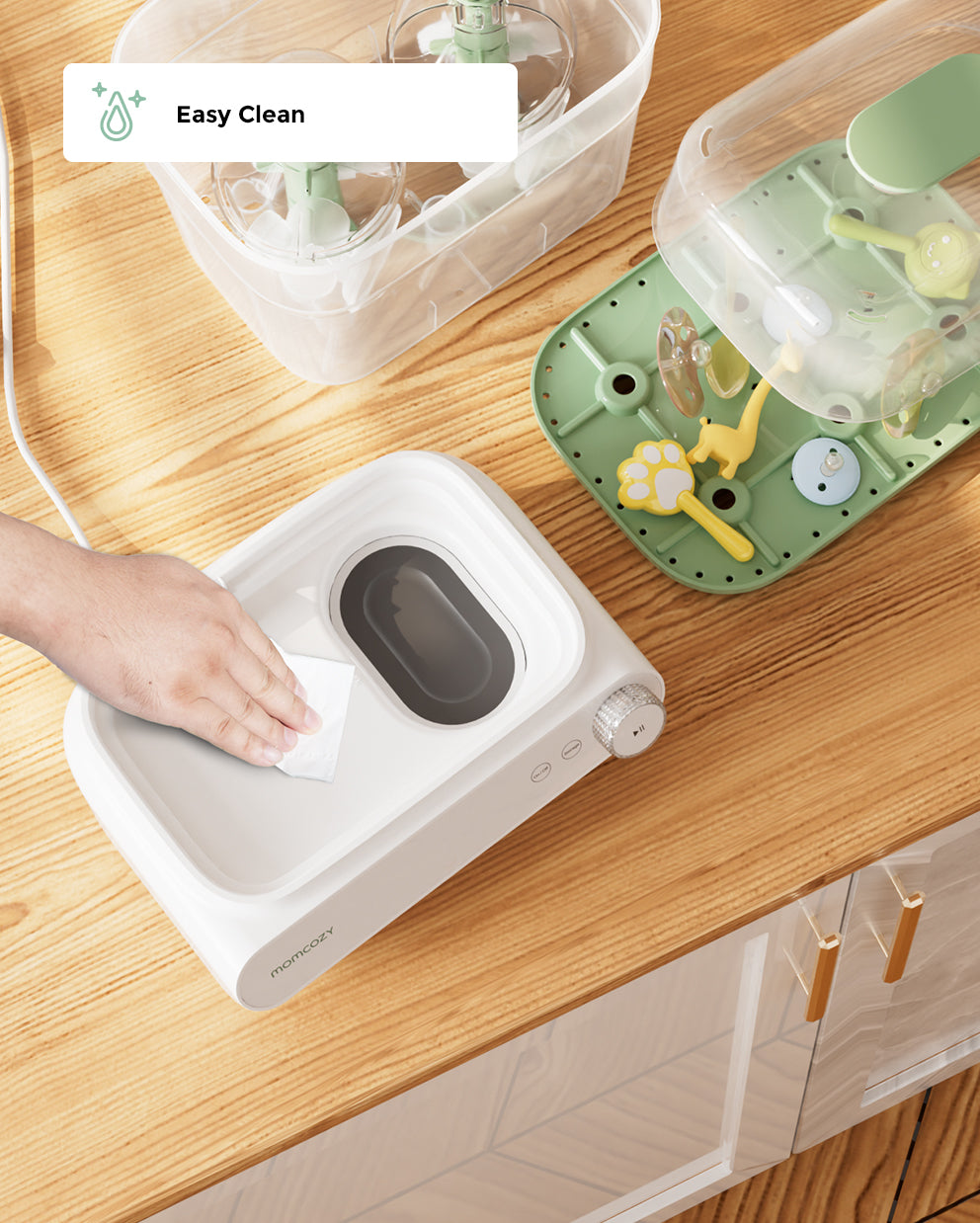 Hand cleaning the Momcozy 3 Layers Bottle Sterilizer and Dryer, showcasing easy maintenance and functionality.