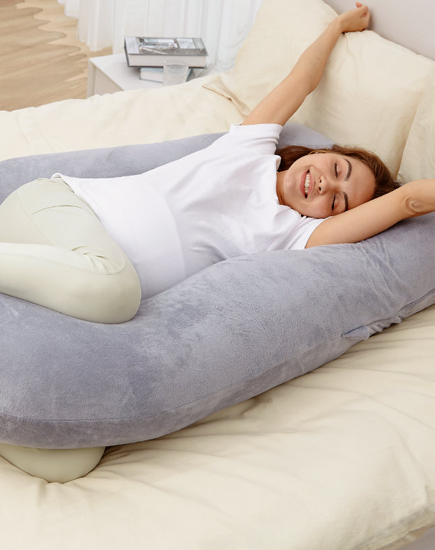 Future maman partageant un moment de repos avec son coussin de grossesse Momcozy