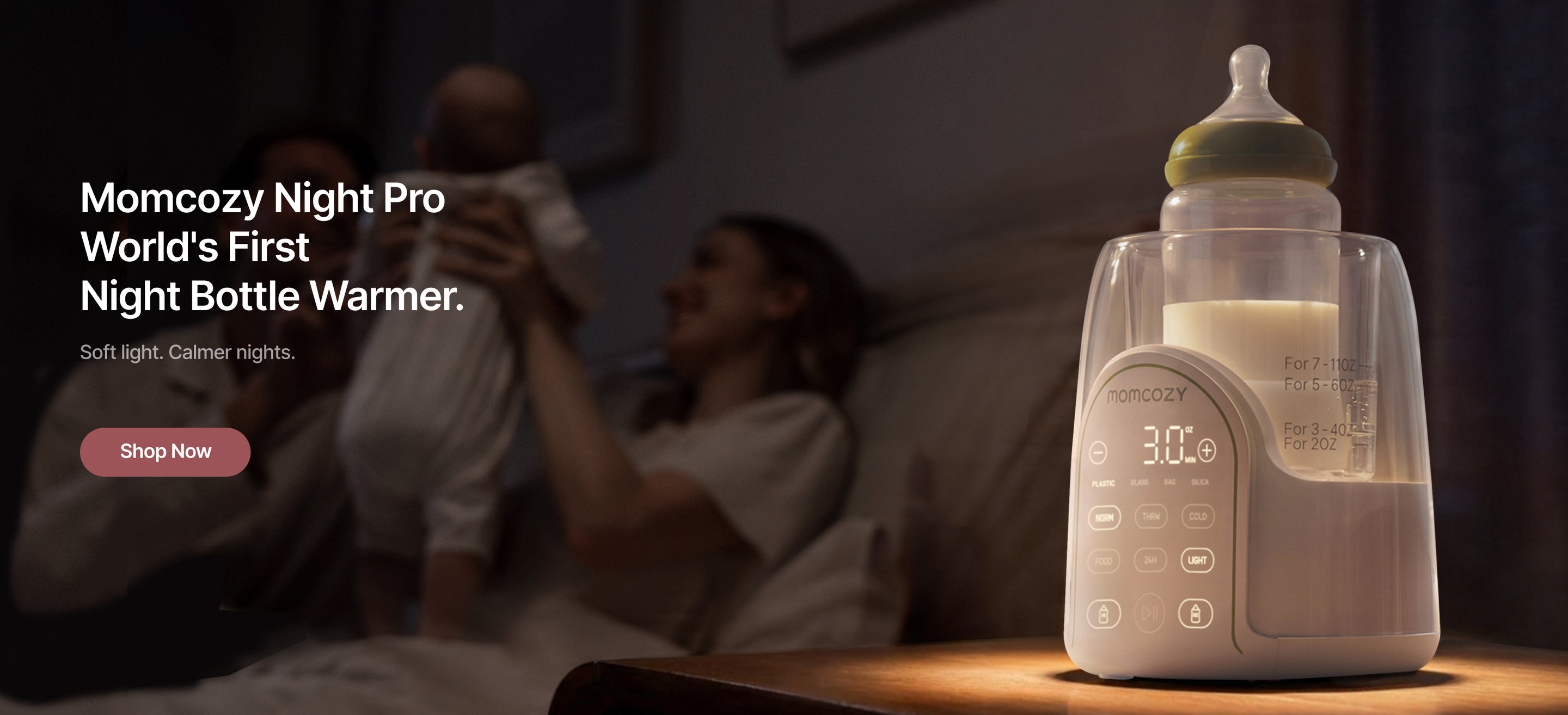 Momcozy Night Pro bottle warmer with a blurred background of a family, highlighting the product's branding and features.