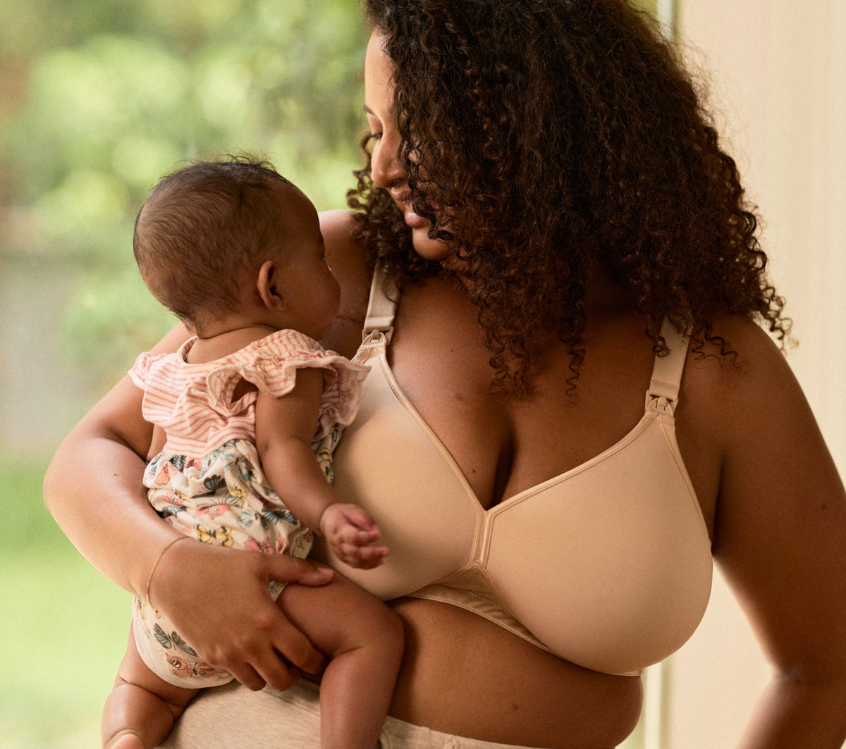 A mother lifting her smiling baby