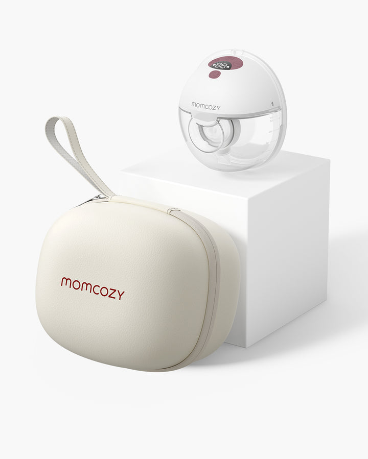 All-in-one M5 Wearable Breast Pump with beige carrying case displayed on a white pedestal, showcasing its portable and stylish design