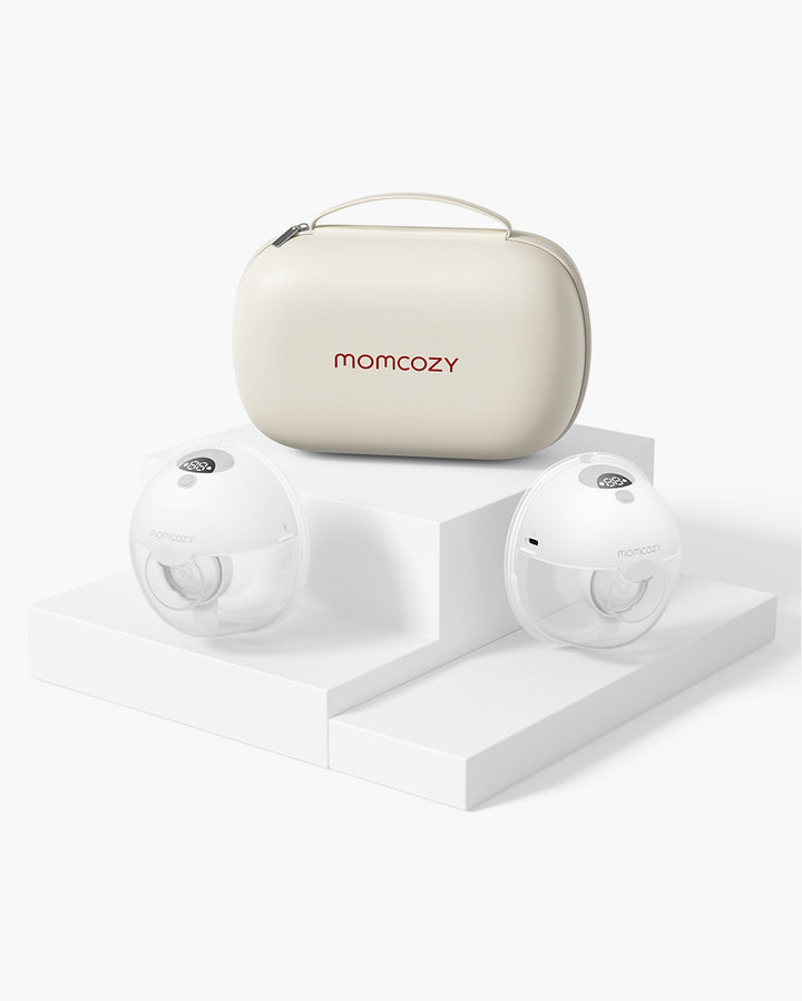 Momcozy M5 Wearable Breast Pump set including two pumps and a beige carrying case on a white stepped platform.
